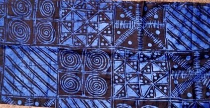 Blue and brown colored Adire Fabric featuring swirls and geometric patterns courtesy of shopafrothreads.com
