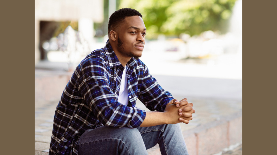 Young African man looking off to distance calmly. The effect of disruption of history and culture on the African youth today.